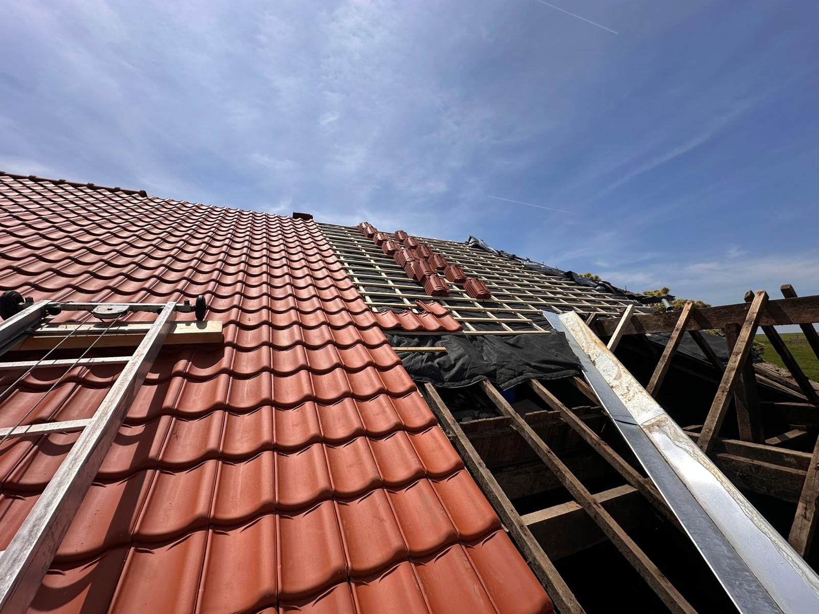 Dakpannen deels verwijderd tijdens reparatie met zichtbaar dakbeschot en panlatten